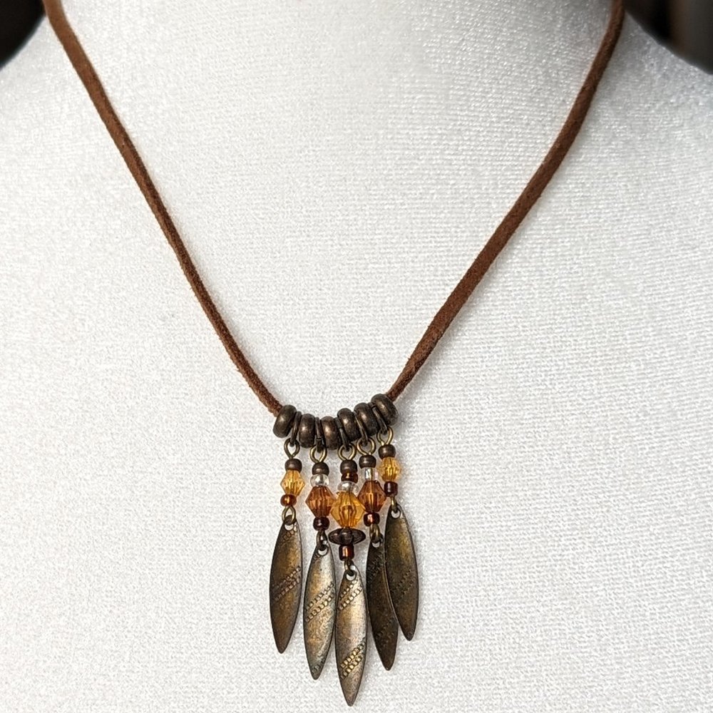 Leather necklace with 5 hammered bronze feather charms hung by strands of beads.